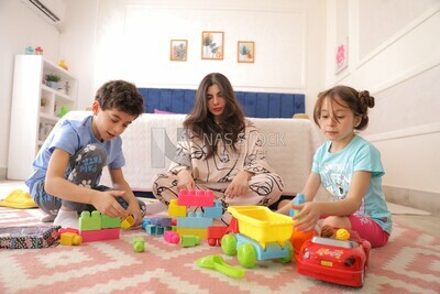 a woman sitting with her children playing