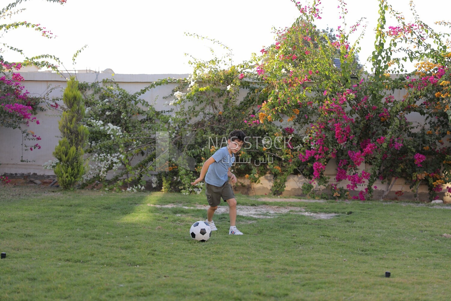 a boy playing football in the garden