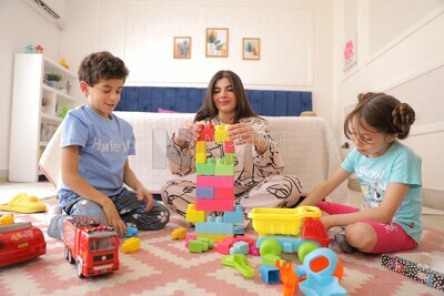 a woman sitting with her children playing