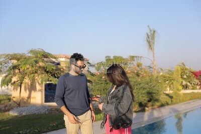 a husband with his wife standing in front of a swimming pool