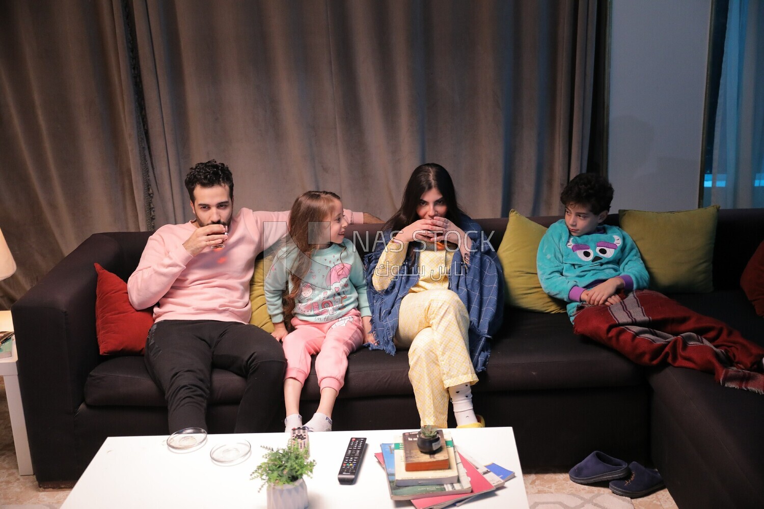 a family of four watching television