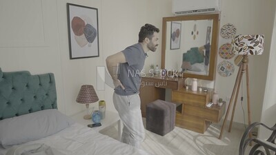 a man  sitting in bed waking up looks tired