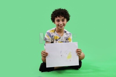 A boy sitting on the floor and drawing