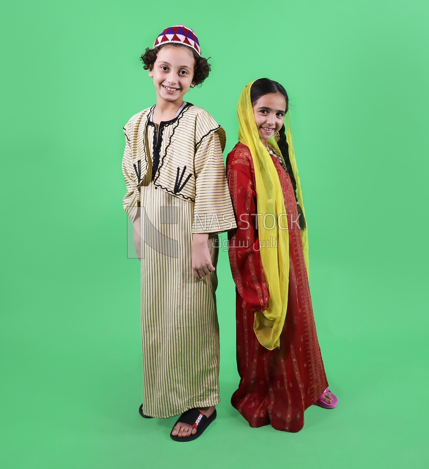 A boy and a girl standing on a green background