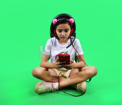 A small girl holding a tablet and wearing a headphone