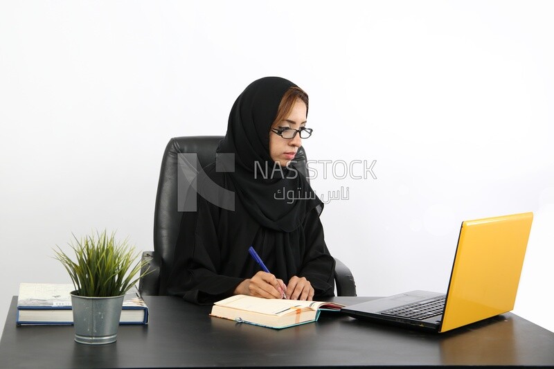A saudi arabian business woman is writing