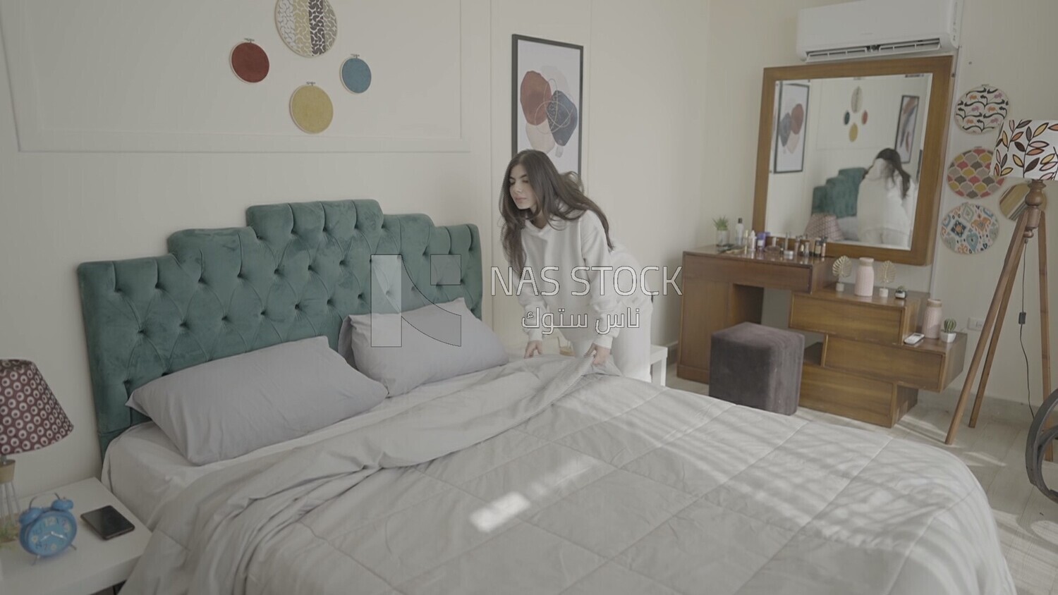 a woman making the bed after she wakes up