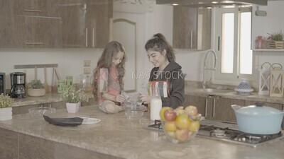 a girl helping her mom in the kitchen