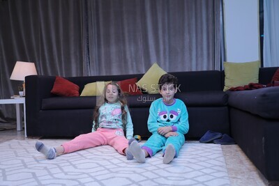 a brother and a sister playing in the living room