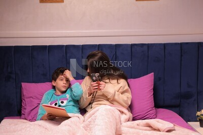 a mother sitting on the phone while her son studies