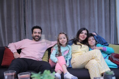 a family of four watching television
