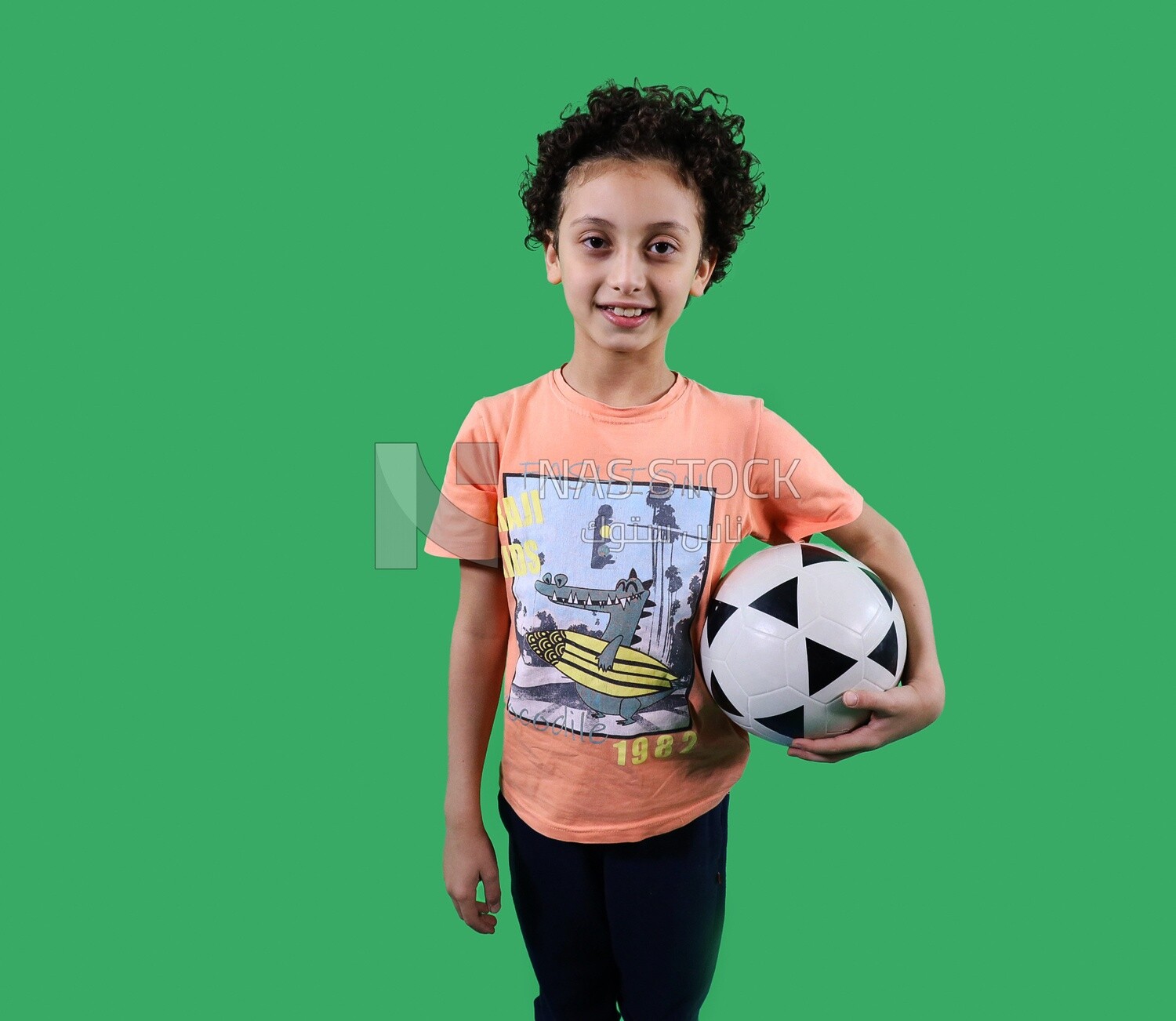A boy standing with a soccer ball