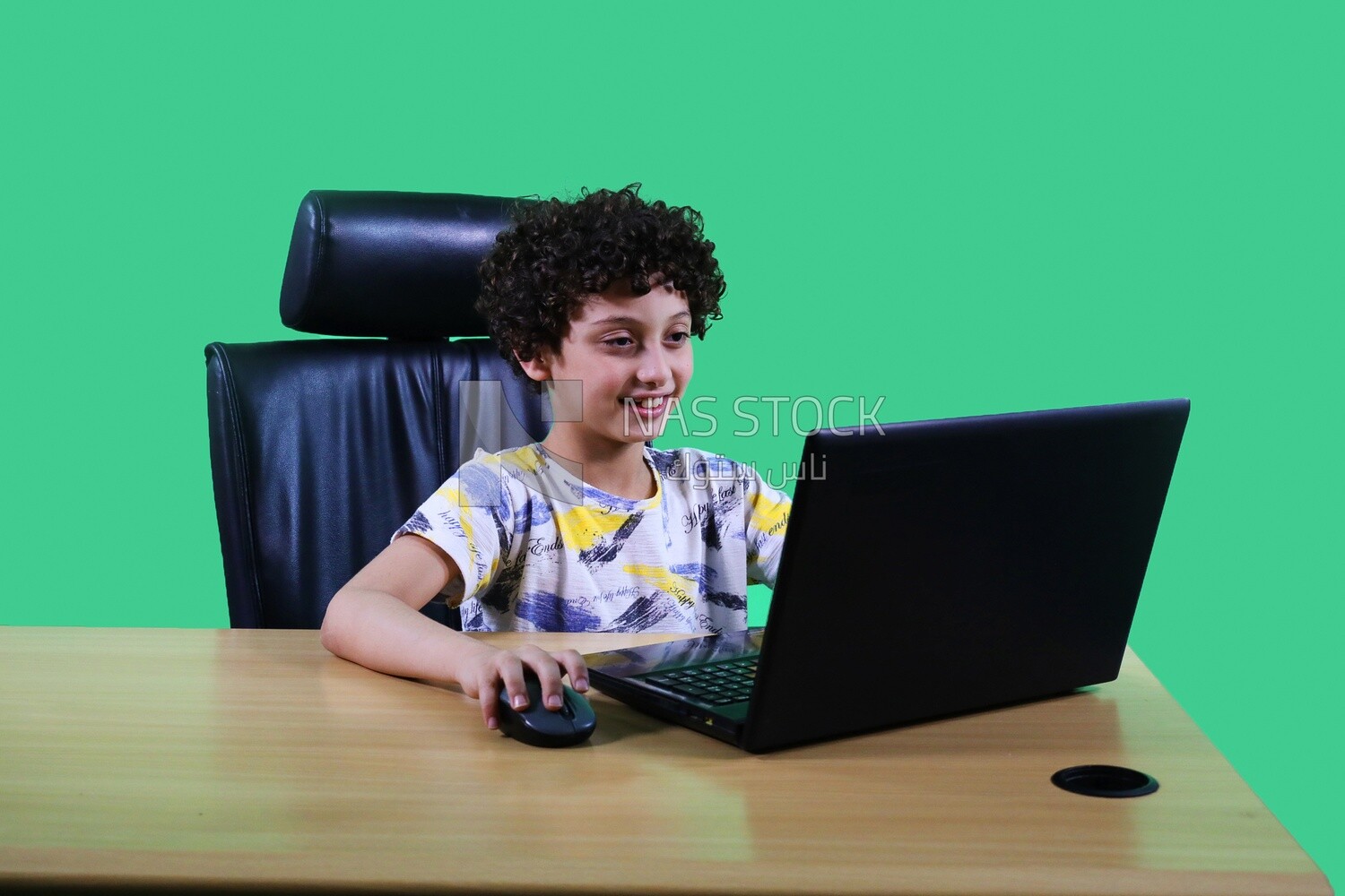 A boy sitting in the office in front of the laptop