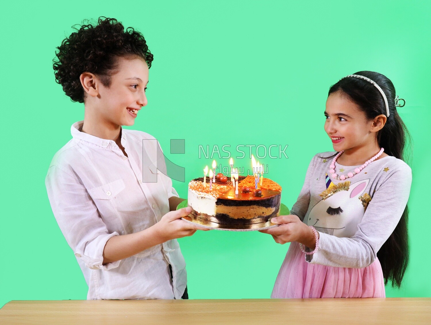 Boy and a girl holding a birthday cake
