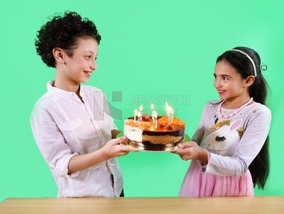 Boy and a girl holding a birthday cake