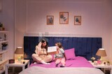 a mother with her daughter drawing together on the bed