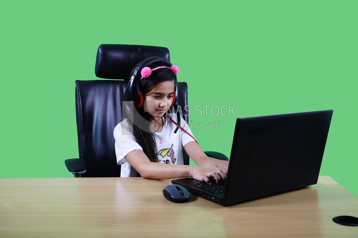 A small girl sitting in the office in front of the laptop