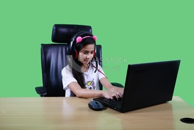 A small girl sitting in the office in front of the laptop