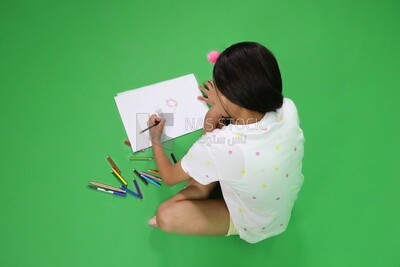 A girl sitting on the floor and drawing