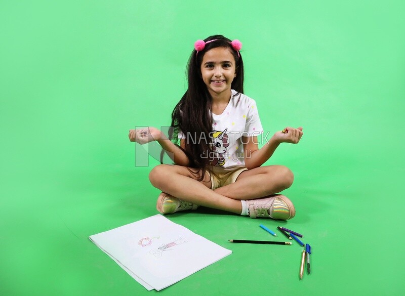 A girl sitting on the floor and drawing