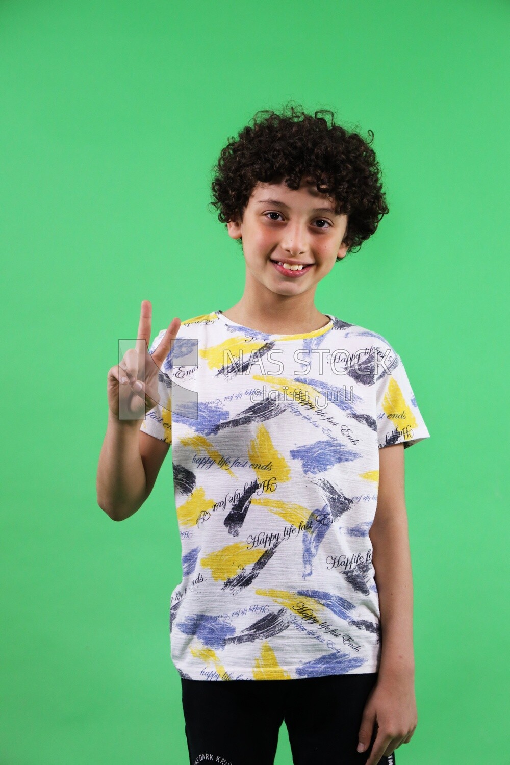 A boy standing on a green background