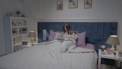a woman reading a story to her son in bed