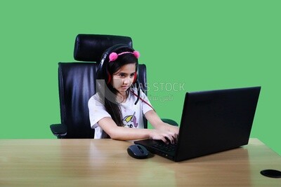 A small girl sitting in the office in front of the laptop