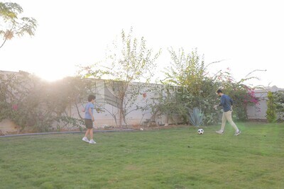 a father playing football with his son in the garden