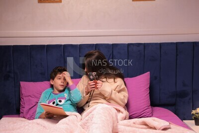 a mother sitting on the phone while her son studies