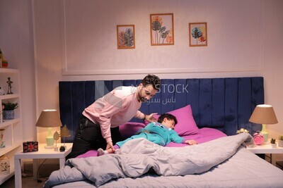 اب يضع ابنه على السرير