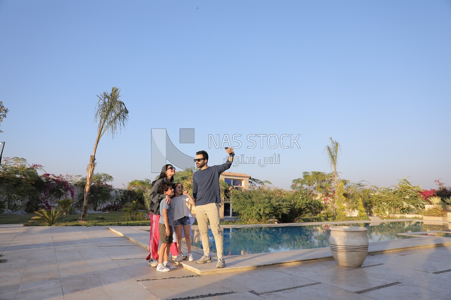 a family of four taking a selfie in the garden