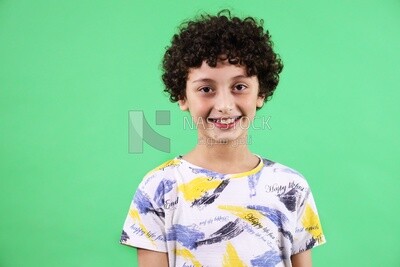 A boy standing on a green background