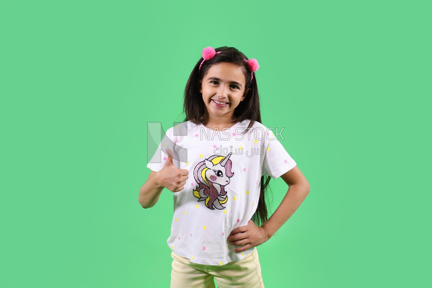 A small girl standing on a green background