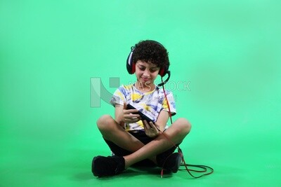 A boy holding a tablet and wearing a headphone