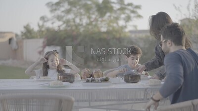 a family preparing a dining table in the garden