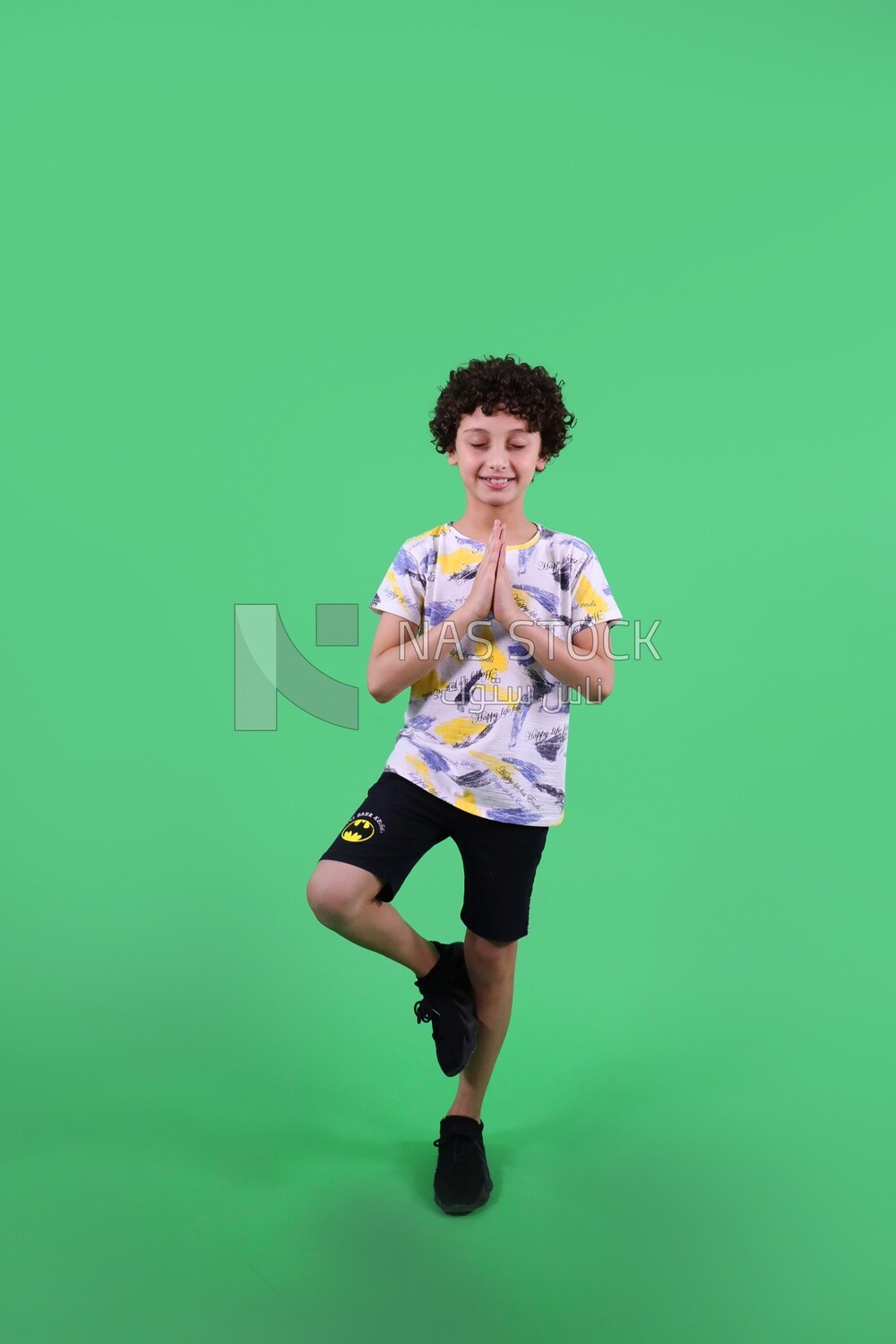 A boy standing on a green background