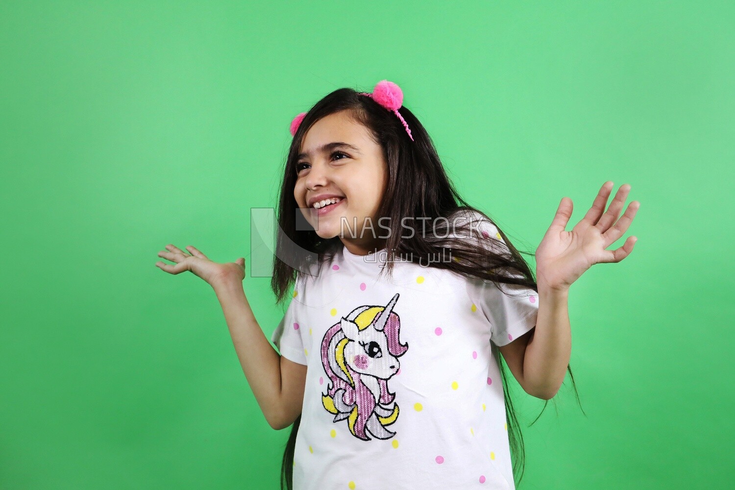 A small girl standing on a green background