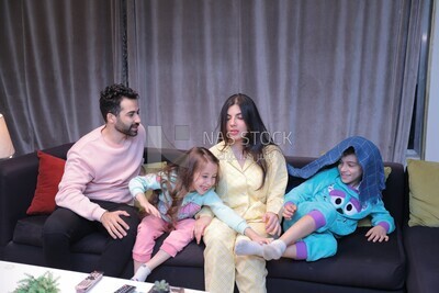 a family of four sitting on the sofa laughing