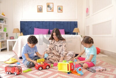 a woman sitting with her children playing