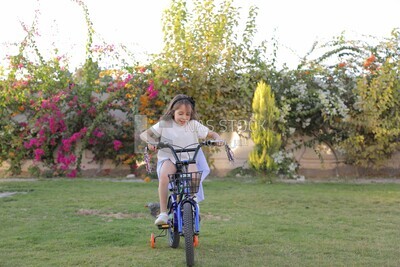 a girl riding a bike in the garden