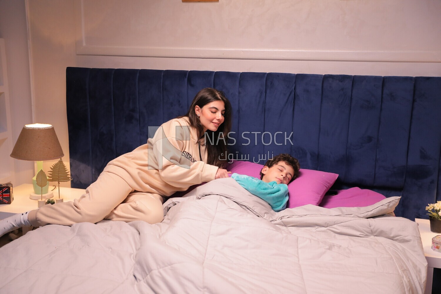 a mother sitting on the bed during his boy&#39;s sleep