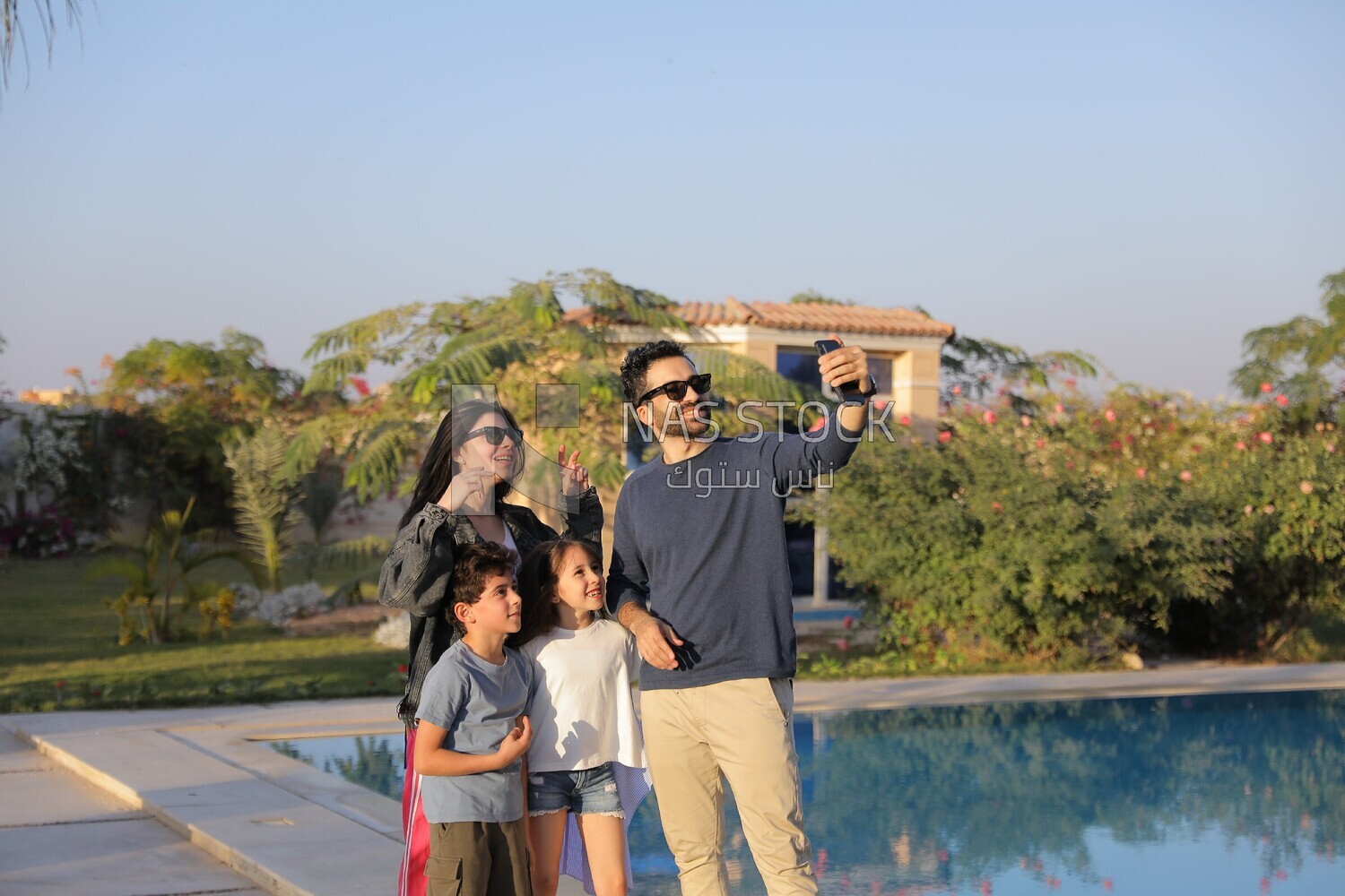 a family of four taking a selfie in the garden