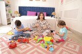 a woman sitting with her children playing