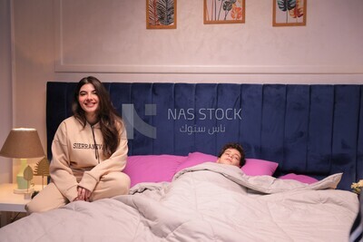 a mother sitting on the bed during his boy&#39;s sleep