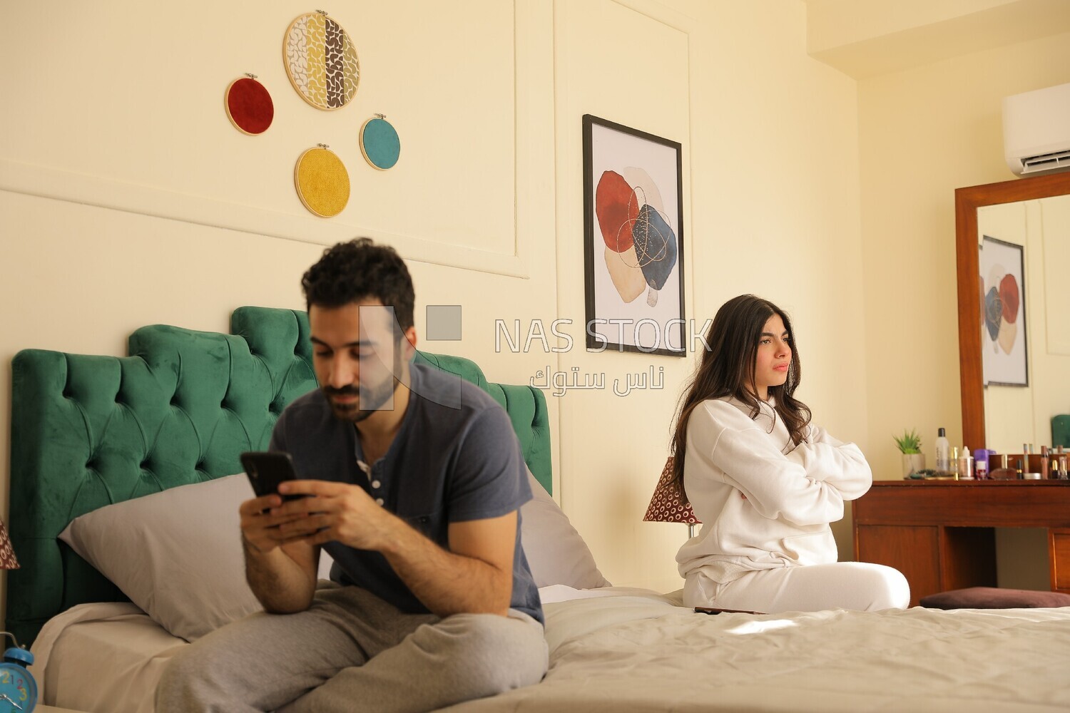 a man texting on the phone while her wife is beside him
