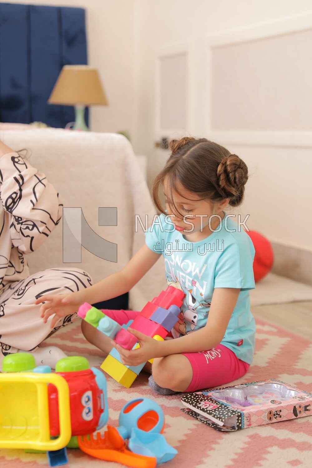 a girl sitting on the floor and playing