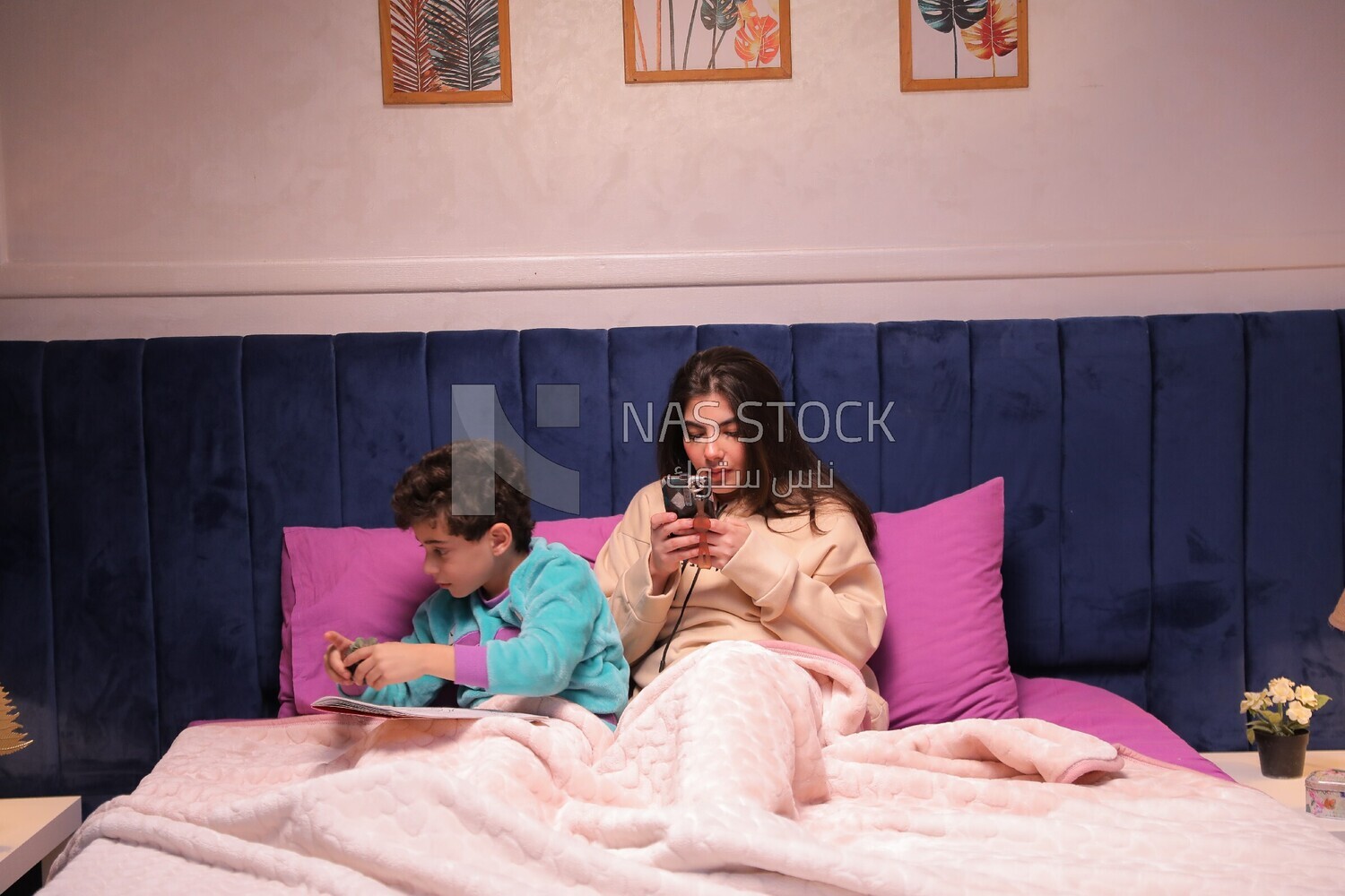 a mother sitting on the phone while her son studies