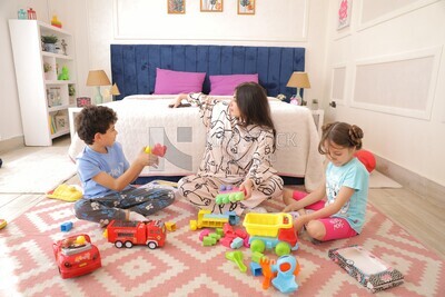 a woman sitting with her children playing