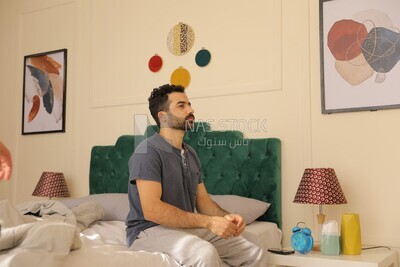 a man  sitting in bed waking up