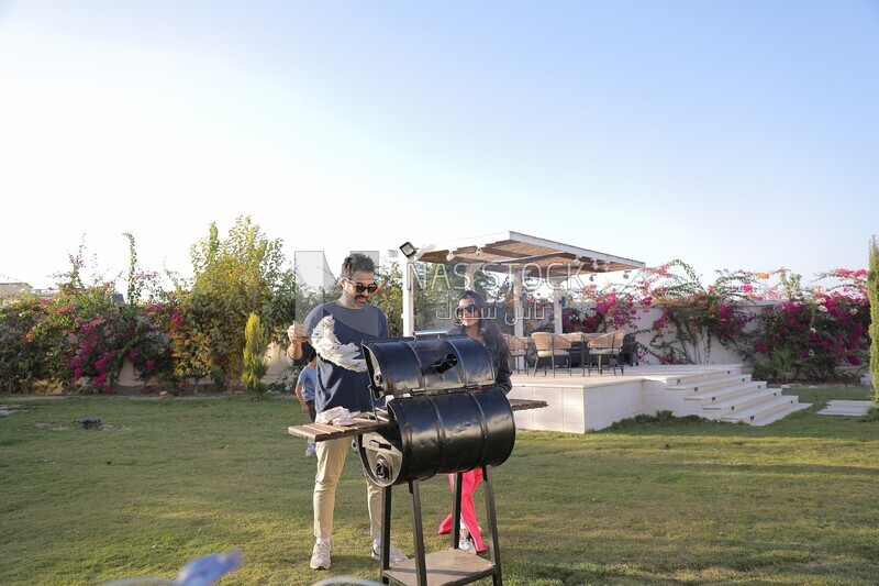 man preparing food on a barbecue grill